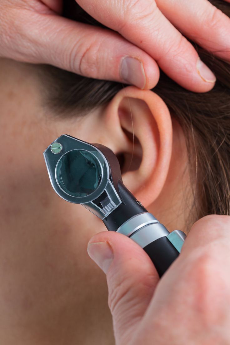 ENT specialist examining patient with otoscope